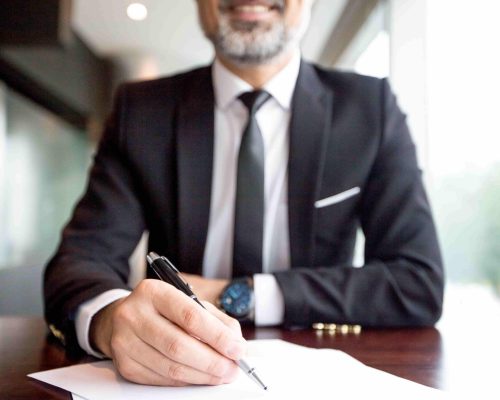 close-up-of-businessman-doing-paperwork-min